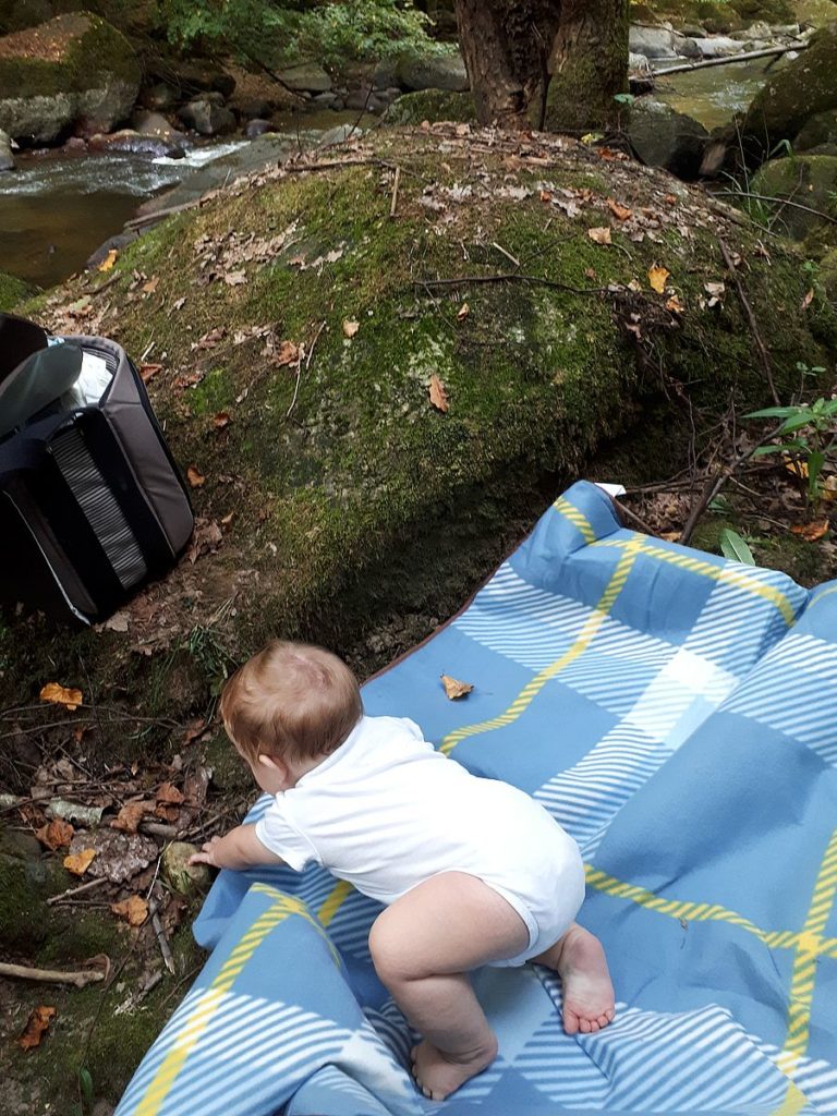 Baby krabbelt auf Picknickdecke im Aisttal